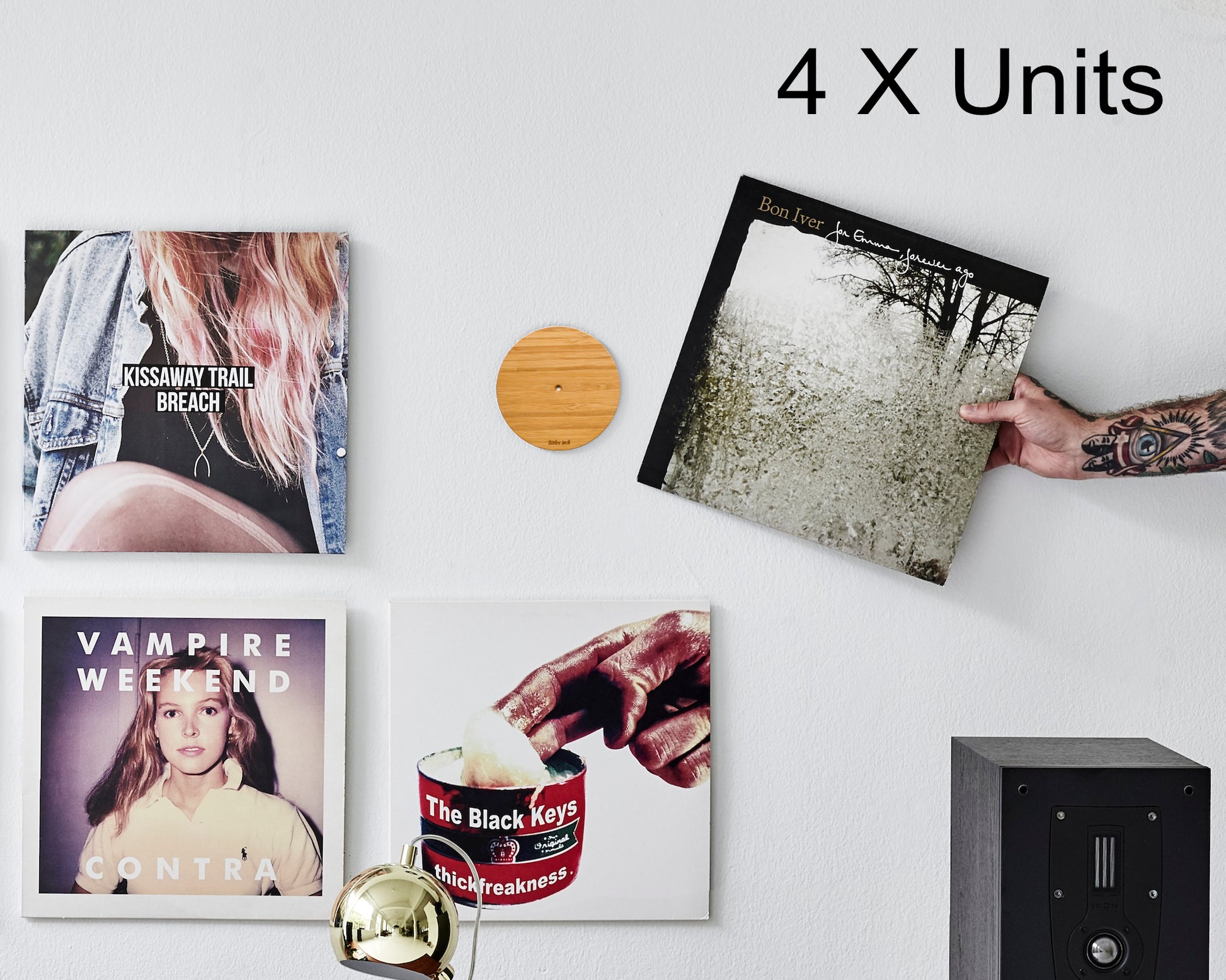 Showing three albums on the wall and a hand that puts a fourth on the small magnetic disc