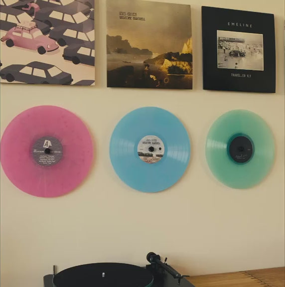 Showing both vinyl records and the albums on the wall, without frames og visible support
